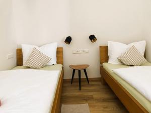two beds in a room with a table between them at Apartment Wendehals in Vogtsburg