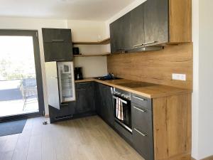 a kitchen with stainless steel appliances and wooden cabinets at Apartment Wendehals in Vogtsburg