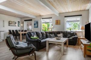 a living room with a leather couch and a table at LF12011-Spottrup-Vadumvej-1-E in Spottrup