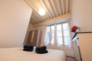 a bedroom with a bed and a window at a charming little apartment in Cluny