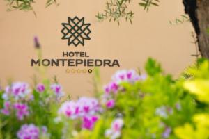 a sign for a hotel with flowers in the foreground at Hotel Montepiedra 4''''sup in Playas de Orihuela +76 photos