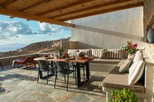 a patio with a table and a couch at Amara Serifos in Serifos Chora