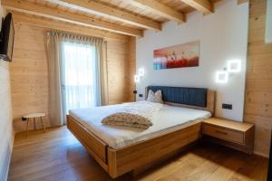 a bedroom with a bed in a room with wooden walls at Chalet am Zirm in Riobianco +7 photos