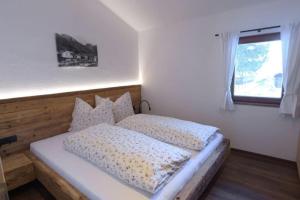 a bedroom with a large bed with a window at Ausserhof Hütte mit Sauna Südtirol in Riobianco