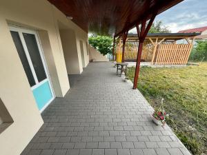 a walkway outside of a house with two benches at István in Sîngeorgiu de Pădure