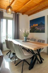 a dining room table with chairs and a vase of flowers at Amara Serifos in Serifos Chora