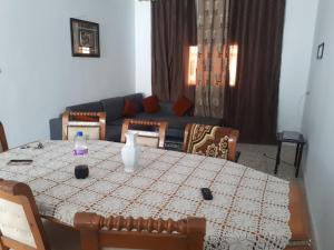 a living room with a table and a couch at Belle vue in Aïn Draham