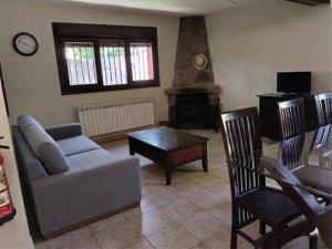 a living room with a couch and a table at Casa Rural en El Burguillo - Puerto Pez in Las Cruceras