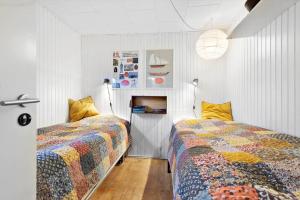 two beds in a bedroom with white walls at 8965-Allingabro-Hasselvej-3 in Skovgårde