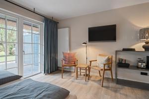 a hotel room with a bed and two chairs at Beach Lodge Beach Lodge Appartement 6 in Böhl
