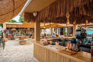 a bar in a resort with people sitting at tables at Newquay beach club in Kavos