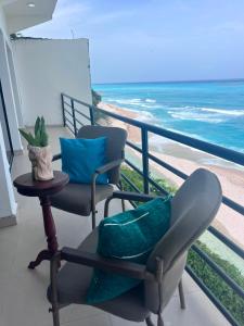a balcony with two chairs and a table and the ocean at Privanza Hotels in Santa Cruz de Barahona +10 photos
