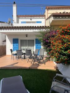 a patio with chairs and a table and flowers at Breda 4a in Torroella de Montgrí