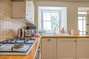 a kitchen with a stove top oven next to a sink at Delfryn in Tenby +31 photos