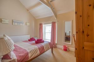 a bedroom with a bed with red pillows on it at Delfryn in Tenby