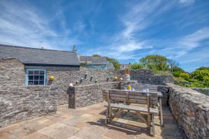 a wooden bench sitting on a stone wall at Delfryn in Tenby