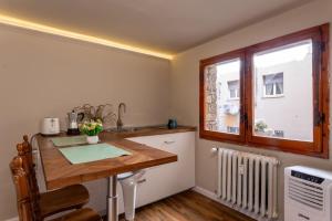 a kitchen with a wooden table and a window at Central Gucciardini house in Florence