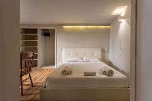 a bedroom with a white bed with two towels on it at Central Gucciardini house in Florence +13 photos