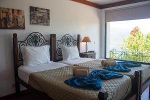 two beds in a bedroom with a large window at Casa Martagão do Gerês by Gerês Casas in Caniçada +66 photos