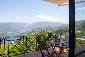 a table and chairs on a balcony with a view at Casa Martagão do Gerês by Gerês Casas in Caniçada