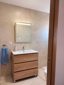 a bathroom with a sink and a mirror and a toilet at Cala Queralt Rooms in Sagunto