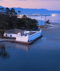 a boat sitting in the water at dusk at Zaya Mar Pousada in Bertioga