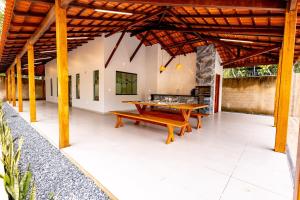 an outdoor patio with a wooden table and a bench at Alter Casa Sawe, Alter do Chão, PA in Santarém