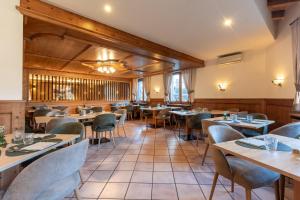 a restaurant with tables and chairs in a room at Family Hotel Adriana in Ledro