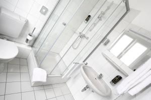 ein weißes Badezimmer mit Dusche und Waschbecken in der Unterkunft Stadthotel Jülich in Jülich
