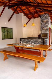 a dining room with a table and benches at Alter Casa Sawe, Alter do Chão, PA in Santarém