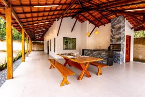 an outdoor dining room with a wooden table and benches at Alter Casa Sawe, Alter do Chão, PA in Santarém