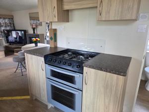 a kitchen with a stove and a counter top at Awesome Static Caravan Holiday Home in Great Billing