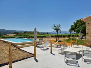 a patio with a pool and chairs and a table at La Fabrique in Gargas
