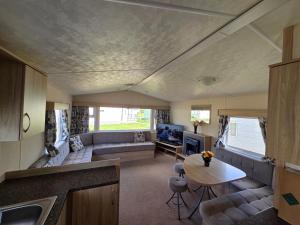 a living room with a couch and a table at Awesome Static Caravan Holiday Home in Great Billing