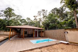 a house with a swimming pool next to a fence at Alter Casa Sawe, Alter do Chão, PA in Santarém