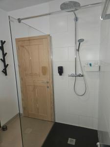 a bathroom with a shower with a wooden door at La Tanière des Loups in Herbeumont +14 photos
