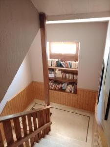 a room with a staircase with a book shelf at Hotel Restaurant La Clairiere in Chambon-sur-Dolore