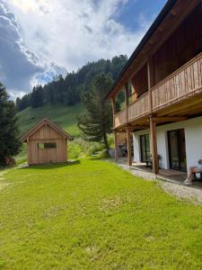 a house with a grass yard next to a building at Almhaus Zwergbirke in Schönfeld in Thomatal