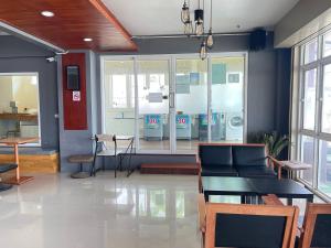 a waiting room with a table and chairs and windows at Bann Lhong Rak Krabi in Krabi