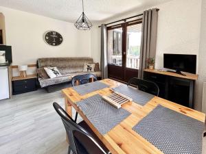 a living room with a dining table and a couch at Studio rénové cœur de station, skis aux pieds - FR-1-322-323 in Les Orres