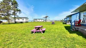 a picnic table in a field next to a building at Blue Spruces Cottages in Hampton 