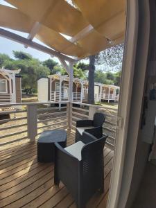 a deck with chairs and a table and some rvs at Campeggio Internazionale Frassanito in Otranto
