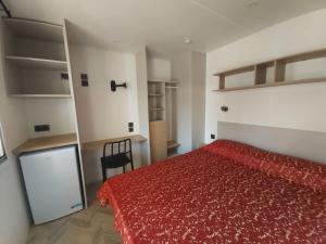 a bedroom with a red bed and a chair at Campeggio Internazionale Frassanito in Otranto