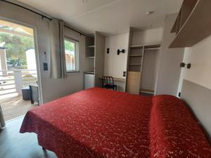 a bedroom with a red bed and a balcony at Campeggio Internazionale Frassanito in Otranto +8 photos