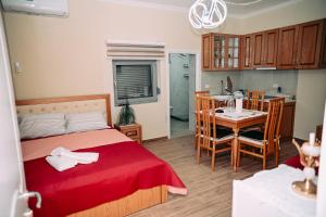 a bedroom with a bed and a table and a kitchen at Vila BENE in Pogradec