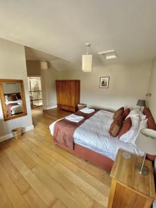 a bedroom with a large bed and a wooden floor at Decoy Country Cottages in Navan