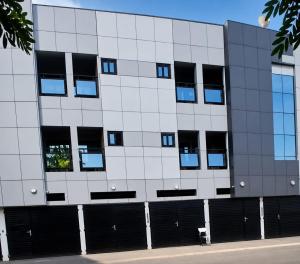 a white building with black windows on a street at Grand Studio Meublé à Lomé in Komé