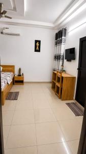a white room with a bed and a tv at Grand Studio Meublé à Lomé in Komé