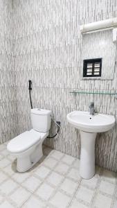 a bathroom with a toilet and a sink at Grand Studio Meublé à Lomé in Komé