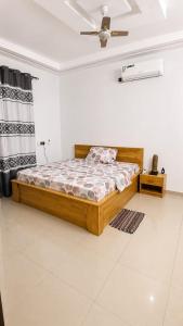 a bedroom with a bed and a ceiling fan at Grand Studio Meublé à Lomé in Komé